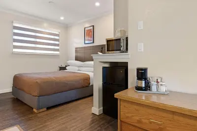 a hotel room with a bed and a microwave at Oasis Inn in Kelowna