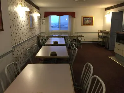 a dining room with tables and chairs and a window at DC Lodge in Dawson Creek