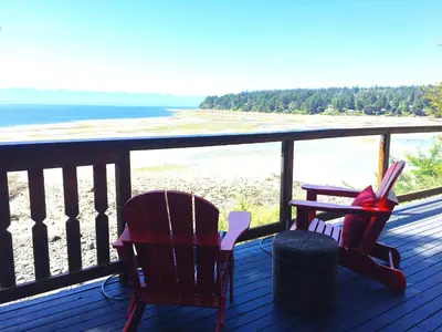 two chairs on a deck with a view of the beach at The Beach House Texada - Gillies Bay Favourite Cabin in Gillies Bay