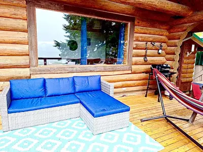 a blue couch sitting on the porch of a cabin at The Beach House Texada - Gillies Bay Favourite Cabin in Gillies Bay
