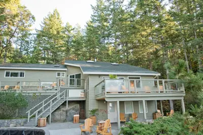 a large house with a deck and a balcony at Rockwater Secret Cove Resort in Sechelt