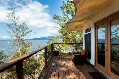 a balcony of a house with a view of the water at Rockwater Secret Cove Resort in Sechelt