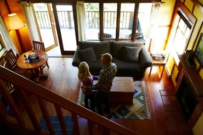 a man and a girl standing in a living room at Middle Beach Lodge in Tofino