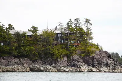 a house on top of an island in the water at Middle Beach Lodge in Tofino