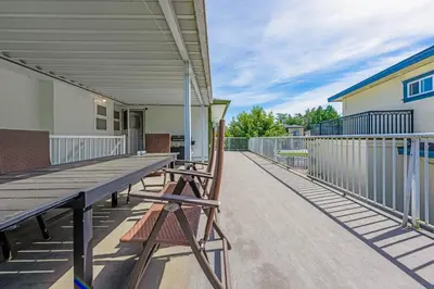 a large deck with a picnic table and chairs at Quite House near the Vancouver Airport in Richmond