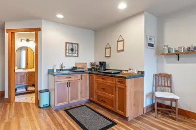 a kitchen with a counter and a sink and a chair at Shawnigan Hills Guest Suite in Shawnigan Lake
