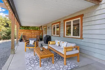 a porch with two chairs and a couch and a table at Shawnigan Hills Guest Suite in Shawnigan Lake