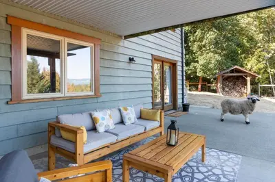 a couch on the porch of a house with a sheep at Shawnigan Hills Guest Suite in Shawnigan Lake