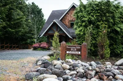 a sign in front of a house with a pile of rocks at Shawnigan Hills Guest Suite in Shawnigan Lake