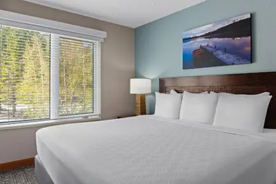 a bedroom with a white bed and two windows at WorldMark Canmore-Banff in Canmore