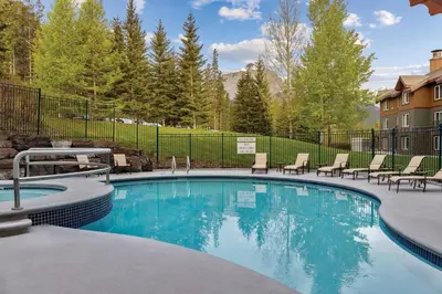 a swimming pool with lounge chairs in a yard at WorldMark Canmore-Banff in Canmore