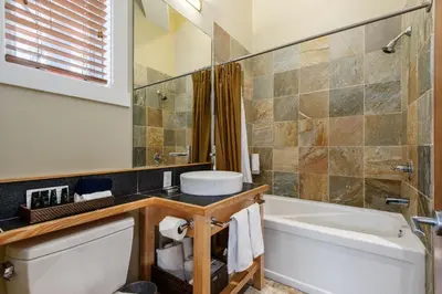 a bathroom with a tub and a toilet and a sink at Cox Bay Beach Resort in Tofino