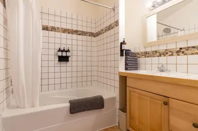 a white bathroom with a tub and a sink at Mackenzie Beach Resort in Tofino