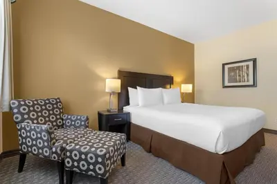a hotel room with a bed and a chair at Best Western Plus Baker Street Inn in Nelson