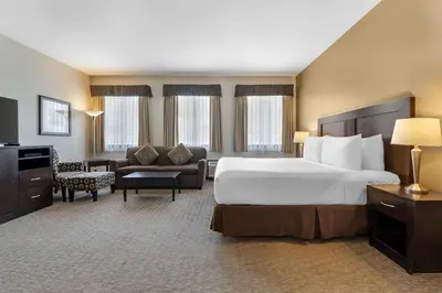 a hotel room with a large bed and a couch at Best Western Plus Baker Street Inn in Nelson