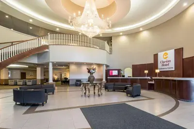 a lobby with a table and chairs and a chandelier at Clarion Hotel & Conference Centre in Sherwood Park