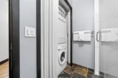 a laundry room with a washer and dryer in it at The Mountaineer by InstantSuites Pool & HotTub in Canmore