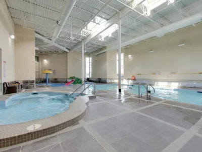 a large indoor swimming pool with a hot tub at The Mountaineer by InstantSuites Pool & HotTub in Canmore