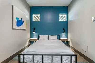 a bed in a room with a blue wall at Nowhere Special Hostel in Rossland