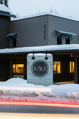 a sign in the snow in front of a building at Nowhere Special Hostel in Rossland