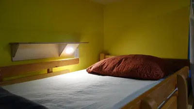 a bedroom with a bed with a red pillow on it at Dreamcatcher Hostel in Golden