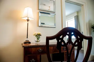 a desk with a lamp and a vase of flowers at The Inn at the Union Club of British Columbia in Victoria
