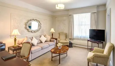 a living room with a couch and a tv at The Inn at the Union Club of British Columbia in Victoria