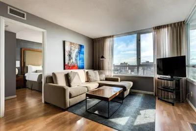 a living room with a couch and a bed at Carmana Hotel & Suites in Vancouver