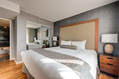 a bedroom with a large white bed and a room at Carmana Hotel & Suites in Vancouver