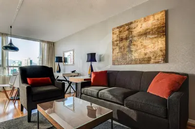 a living room with a couch and a table at Carmana Hotel & Suites in Vancouver