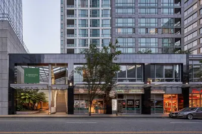 a building with a car parked in front of it at Carmana Hotel & Suites in Vancouver