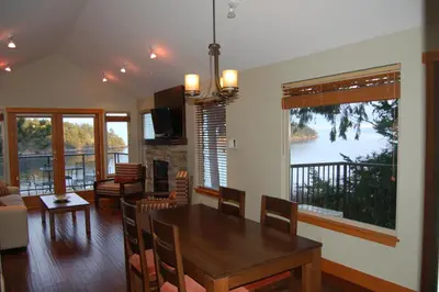 a dining room and living room with a table and chairs at Mayne Island Resort in Mayne Island