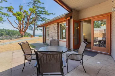 a patio with a table and chairs on a house at Mayne Island Resort in Mayne Island