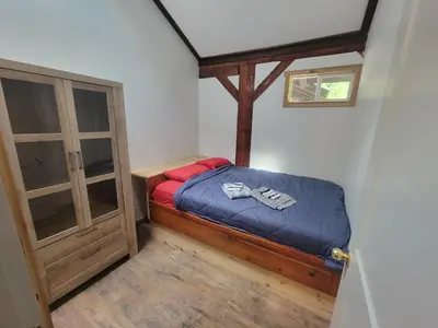 a small bedroom with a bed and a cabinet at Noah's Ark Campground in Revelstoke