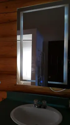a bathroom with a sink and a mirror with a light at Twin Peaks Resort in Valemount