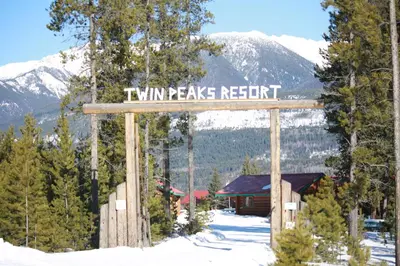 a sign that reads twin peaks resort in the snow at Twin Peaks Resort in Valemount