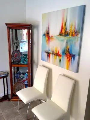 two white chairs in a room with a painting on the wall at Black Sea Motel in Penticton