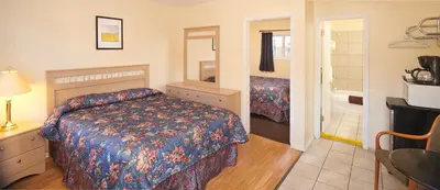 a hotel room with a bed and a bathroom at Black Sea Motel in Penticton