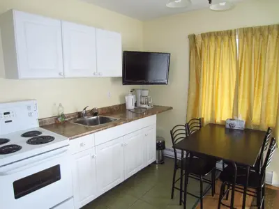 a kitchen with a table and a sink and a stove at Black Sea Motel in Penticton