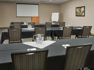 a conference room with tables and chairs and a whiteboard at Neighbourhood Inn Hotels in Bonnyville in Bonnyville
