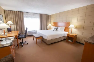 a hotel room with a bed and a desk at Neighbourhood Inn Hotels in Bonnyville in Bonnyville