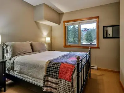 a bedroom with a bed and a window at Suites with Pool & Hot tubs managed by Little Sister Getaways in Canmore