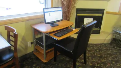 a desk with a computer monitor and a keyboard at Super 8 by Wyndham Revelstoke BC in Revelstoke