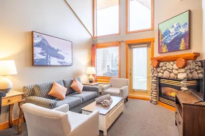 a living room with a couch and a fireplace at Lizard Creek Lodge in Fernie