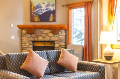 a living room with a couch and a fireplace at Lizard Creek Lodge in Fernie