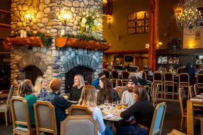 a group of people sitting at tables in a restaurant at Lizard Creek Lodge in Fernie