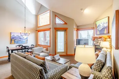 a living room with couches and a tv at Lizard Creek Lodge in Fernie