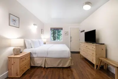 a bedroom with a large bed and a television at West Coast Trail Lodge in Port Renfrew
