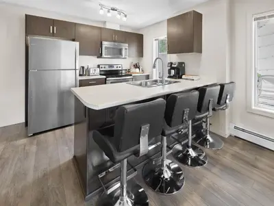 a kitchen with a island with black bar stools at 5 STAR Business Luxury Homeshare in Edmonton