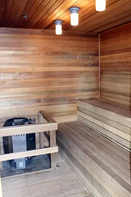 an empty sauna with wooden walls and wooden floors at Chateau Inn & Suites Bonnyville in Bonnyville